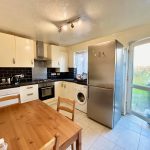 Modern kitchen with appliances and dining table.
