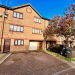 Brick townhouse with parked car and driveway