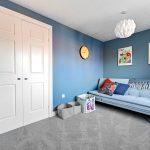 Blue room with sofa, wall clock, and paintings.