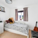 Cosy bedroom with guitar, teddy bears, and artwork.
