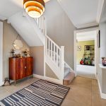 Modern hallway with stairs and guitar room.