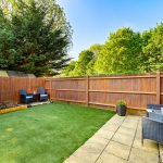 Sunny garden with patio and seating area.