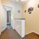 Bright hallway with photos and wicker basket.