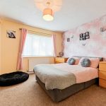 Cosy bedroom with pink and grey decor.