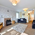 Spacious living room with TV, sofas, and fireplace.