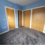 Empty room with blue walls and wardrobes.