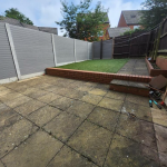 Paved garden patio with raised grass area.