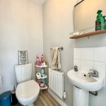 Small bathroom with toilet, sink, and toiletries.