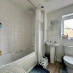 Modern bathroom with bathtub, sink, and toilet.