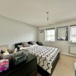 Modern bedroom with large bed and decor accessories.