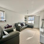 Modern living room with leather sofas and TV.