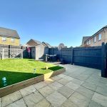 Backyard with artificial grass and basketball hoop.
