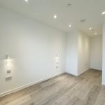 Empty room with wooden floor and white walls.