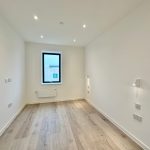 Minimalistic empty room with wooden floor and window.