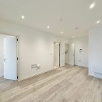 Empty modern room with wooden flooring.