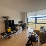 Bright living room with sofa and desk area.