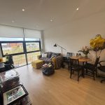 Modern living room with large window and cosy furniture.