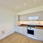 Modern kitchen with white cabinets and built-in oven.