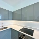 Modern kitchen with sleek grey cabinets and appliances.
