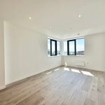 Modern empty room with large windows and wooden floor.
