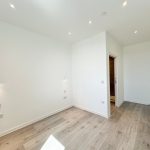 Minimalist empty room with wooden floor and lights.