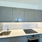 Modern kitchen with grey cabinets and induction hob.