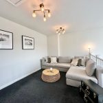 Stylish lounge with grey sofa and modern lighting.