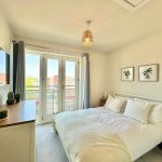Bright bedroom with double bed and balcony view.
