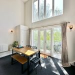 Bright dining room with large windows and table.