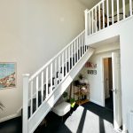 Bright hallway with stairs and wall art