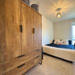 Cosy bedroom with large wardrobe and bed.