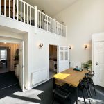 Bright room with mezzanine and dining table.