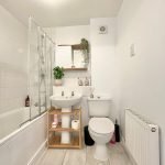 Modern bathroom with bathtub and plants.