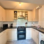 Modern kitchen with wooden cabinets and appliances.