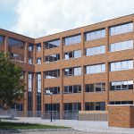 Modern brick office building with parking.