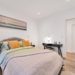 Modern bedroom with stylish decor and desk.