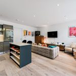 Modern open-plan living room with kitchen and decor.