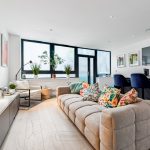 Modern living room with colourful cushions and plants.