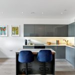 Modern kitchen with grey cabinets and breakfast bar.