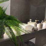 Bathroom with fern, towels, and toiletries on shelf.