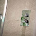Modern chrome shower controls on tiled wall