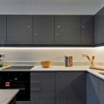 Modern kitchen with grey cabinets and white surfaces.