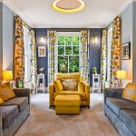 Bright living room with grey sofas and yellow accents.