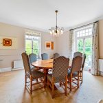 Spacious dining room with large wooden table.