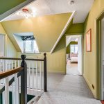 Loft conversion hallway with green walls and skylights.