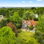 Aerial view of a countryside house surrounded by trees.