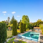 Garden with pool and playground, sunny day.