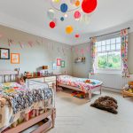 Colourful children's bedroom with twin beds and toys.