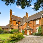 Charming Victorian house with lush garden and driveway.