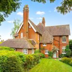 Victorian-style brick house with manicured garden.